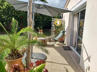 a patio with an umbrella and some plants at Suite indépendante avec vue in Sarrola-Carcopino