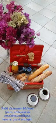a red basket with flowers and bread on the floor at Suite indépendante avec vue in Sarrola-Carcopino