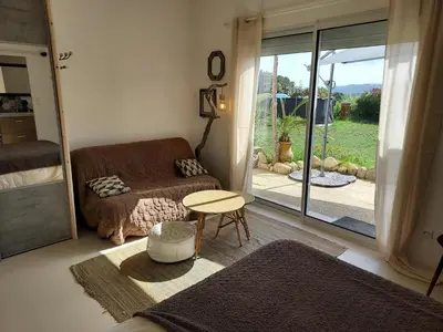 a living room with a couch and a table at Suite indépendante avec vue in Sarrola-Carcopino