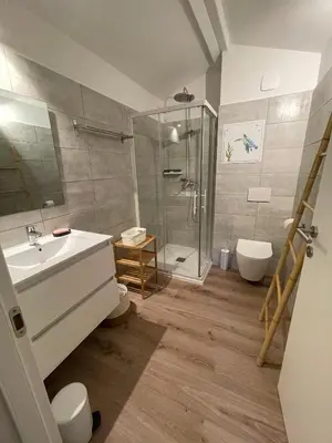 a bathroom with a sink and a shower at Mini Villa T4 duplex dans résidence hôtelière Fiori di Cala Rossa superbement arborée rénovée en 2023 - chez Anne avec piscine chauffée in Lecci