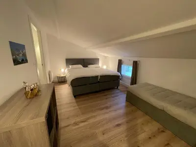 a large bedroom with a bed and a couch at Mini Villa T4 duplex dans résidence hôtelière Fiori di Cala Rossa superbement arborée rénovée en 2023 - chez Anne avec piscine chauffée in Lecci