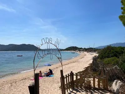 a group of people sitting on a beach at Mini Villa T4 duplex dans résidence hôtelière Fiori di Cala Rossa superbement arborée rénovée en 2023 - chez Anne avec piscine chauffée in Lecci