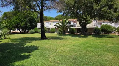 a house in a yard with trees and grass at Mini Villa T4 duplex dans résidence hôtelière Fiori di Cala Rossa superbement arborée rénovée en 2023 - chez Anne avec piscine chauffée in Lecci