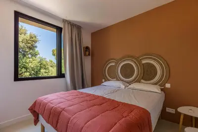 a bedroom with a large bed and a window at Corsica Hostel Porto Vecchio - partie chambre privée in Porto-Vecchio