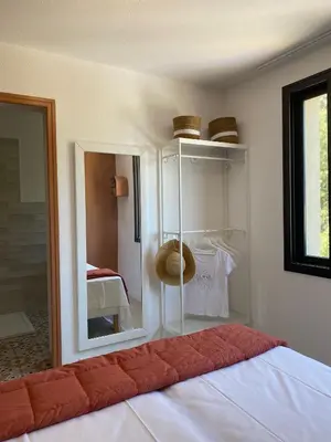 a bedroom with a white bed with a mirror and a room at Corsica Hostel Porto Vecchio - partie chambre privée in Porto-Vecchio