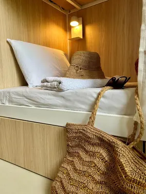 a bed in a room with a bag on it at Corsica Hostel Porto Vecchio - partie chambre privée in Porto-Vecchio