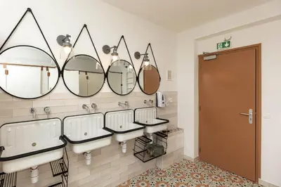 a bathroom with four sinks and mirrors on the wall at Corsica Hostel Porto Vecchio - partie chambre privée in Porto-Vecchio
