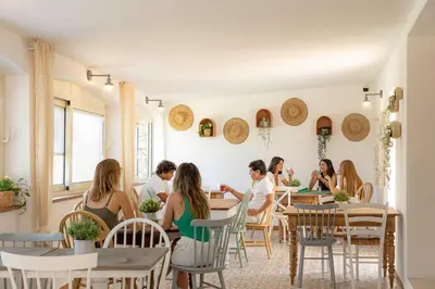 a group of people sitting at tables in a restaurant at Corsica Hostel Porto Vecchio - partie chambre privée in Porto-Vecchio