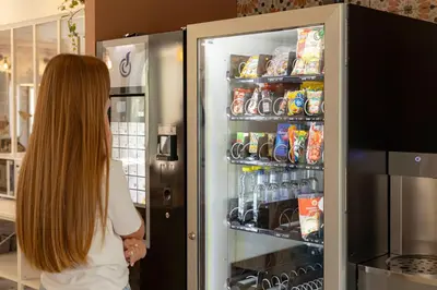 a woman is looking inside of an open refrigerator at Corsica Hostel Porto Vecchio - partie chambre privée in Porto-Vecchio