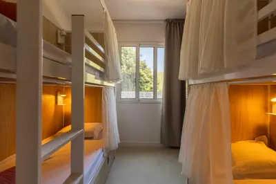 a bedroom with two bunk beds and a window at Corsica Hostel Porto Vecchio - partie chambre privée in Porto-Vecchio