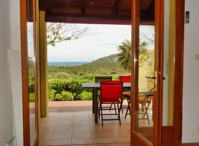 a dining room with a view of the ocean at U Sole Livante mini villa vue mer Santa Giulia in Porto-Vecchio