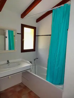 a bathroom with a tub and a sink and a mirror at U Sole Livante mini villa vue mer Santa Giulia in Porto-Vecchio