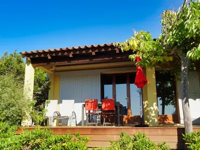 a house with two chairs and a table on a porch at U Sole Livante mini villa vue mer Santa Giulia in Porto-Vecchio