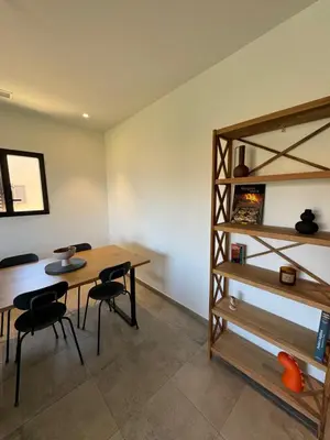 a room with a table and chairs and a shelf at T3 de standing à Piana in Piana