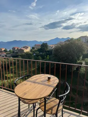 a wooden table and two chairs on a deck with a view at T3 de standing à Piana in Piana