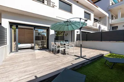 a wooden deck with a table and an umbrella at Paradisu - Apt climatisé de 32 m² in Porticcio