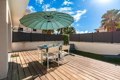 a patio with a table and an umbrella at Paradisu - Apt climatisé de 32 m² in Porticcio