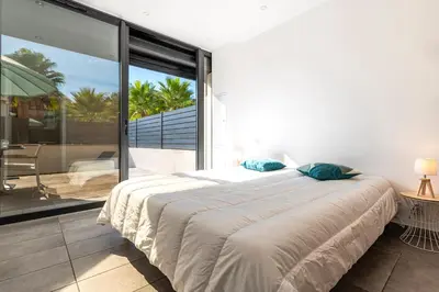 a bedroom with a large bed and a balcony at Paradisu - Apt climatisé de 32 m² in Porticcio