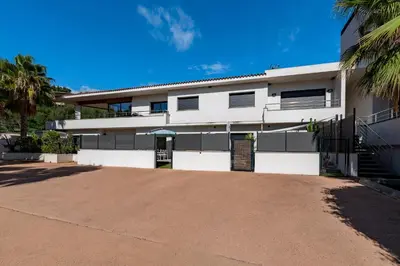 a white building with a driveway in front of it at Paradisu - Apt climatisé de 32 m² in Porticcio