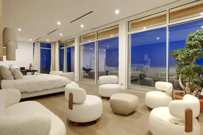 a bedroom with white furniture and a large window at Tigliola Resort in Porto-Vecchio