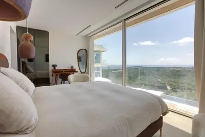 a bedroom with a bed and a large window at Tigliola Resort in Porto-Vecchio