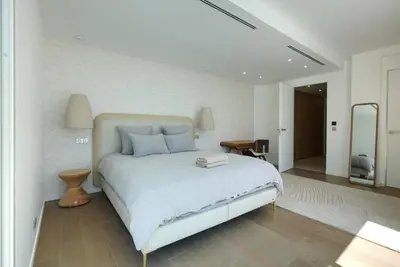 a white bedroom with a bed and a mirror at Tigliola Resort in Porto-Vecchio