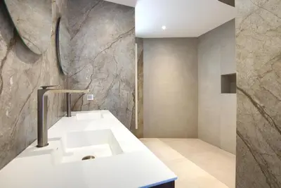 a bathroom with a white sink and a stone wall at Tigliola Resort in Porto-Vecchio