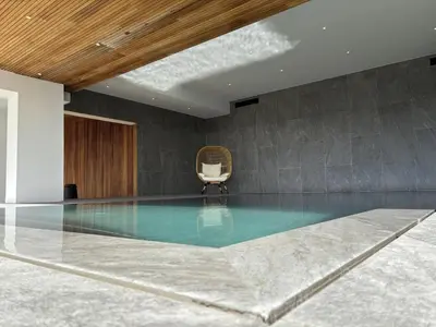 a swimming pool in a room with a chair at Tigliola Resort in Porto-Vecchio