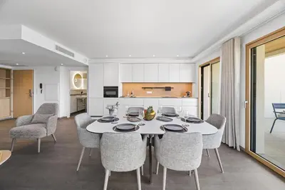 a dining room with a white table and chairs at Novaya Suites in Ajaccio