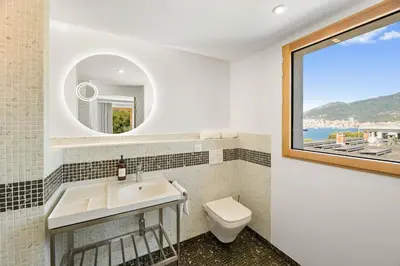 a bathroom with a sink and a toilet and a window at Novaya Suites in Ajaccio