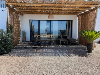 a wooden deck with a table and a bench at T2 standing 50m2, vue mer in Albitreccia