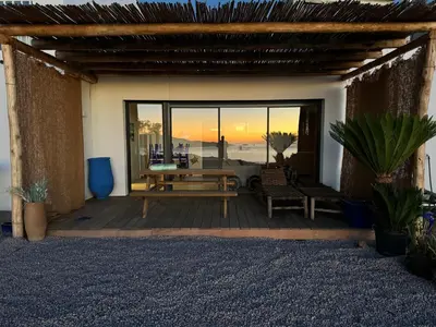 a deck with a table and chairs and a sunset at T2 standing 50m2, vue mer in Albitreccia