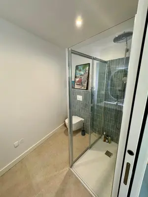 a bathroom with a toilet and a glass shower at T2 standing 50m2, vue mer in Albitreccia