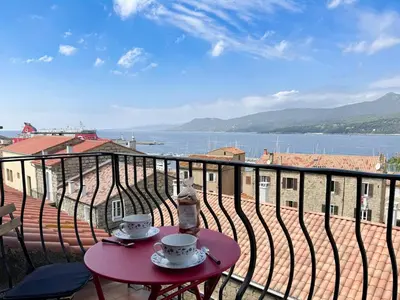 a table with two cups on top of a balcony at Joli T3 moderne avec vue imprenable sur la mer in Propriano