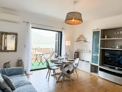 a living room with a couch and a table with chairs at Joli T3 moderne avec vue imprenable sur la mer in Propriano