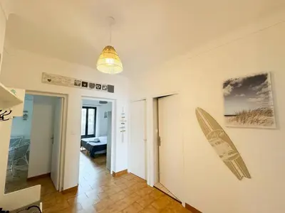 a room with a surfboard hanging on the wall at Joli T3 moderne avec vue imprenable sur la mer in Propriano