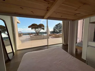 a bedroom with a bed and a view of a patio at Villa Tigliola in Porto-Vecchio