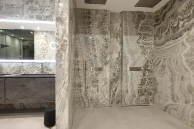a bathroom with a shower with a stone wall at Villa Tigliola in Porto-Vecchio