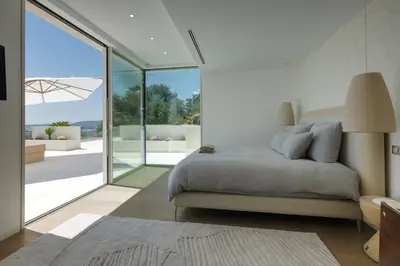 a bedroom with a bed and sliding glass doors at Villa Tigliola in Porto-Vecchio