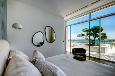 a bedroom with a bed and a view of the ocean at Villa Tigliola in Porto-Vecchio