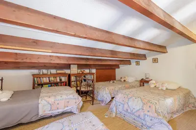 a bedroom with three beds and a book shelf at Maison du Fangu - Da Simone - Maison de 160 m2 in Galeria