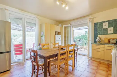 a kitchen and dining room with a wooden table and chairs at Maison du Fangu - Da Simone - Maison de 160 m2 in Galeria