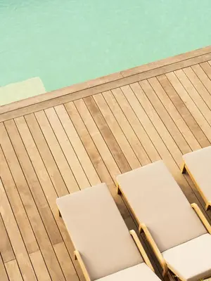 two lounge chairs on a deck next to a swimming pool at Résidence & Villas Oradoro - Proche Île Rousse in Belgodère