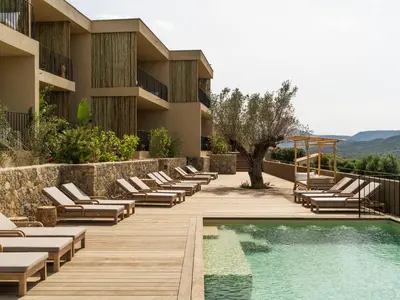 a resort with a pool and lounge chairs at Résidence & Villas Oradoro - Proche Île Rousse in Belgodère