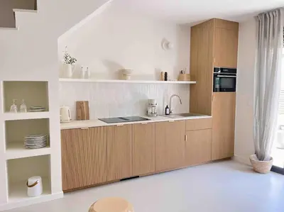 a kitchen with wooden cabinets and a stove top oven at LA GRANDE JANE petite villa bord de mer in Borgo