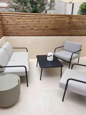 a patio with two chairs and a table with at LA GRANDE JANE petite villa bord de mer in Borgo