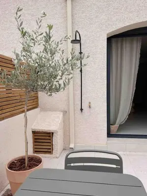 a table and two chairs and a potted tree at LA GRANDE JANE petite villa bord de mer in Borgo