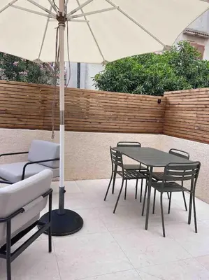a table and chairs with an umbrella on a patio at LA GRANDE JANE petite villa bord de mer in Borgo