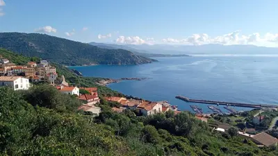 a town on a hill overlooking a body of water at T2 neuf situation Topissime village de Cargèse Vue mer Toutes commodités in Cargèse