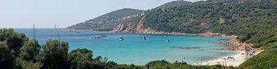 a beach with a bunch of people in the water at T2 neuf situation Topissime village de Cargèse Vue mer Toutes commodités in Cargèse